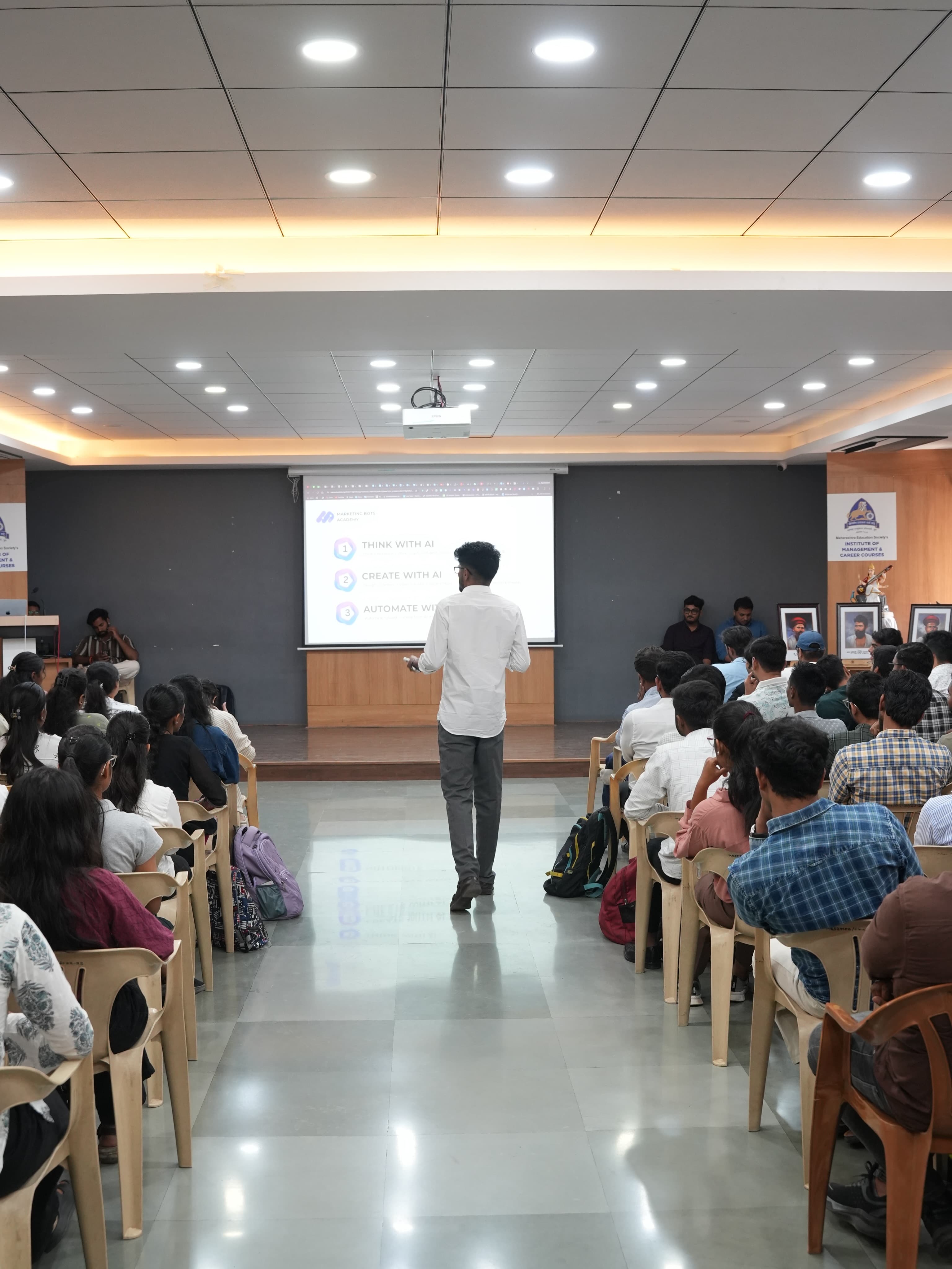 Mentor walking through an AI workshop in a packed hall